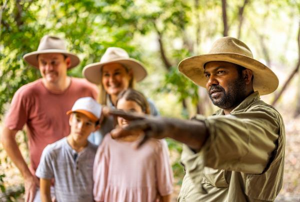 Culture Connect guide pointing as family listen in background, Tropical North Queensland © Tourism Australia