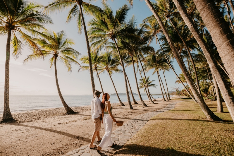 Couple walking under the coconut palms, Palm Beach, Queensland © Tourism and Events Queensland