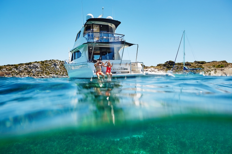 Couple sitting on the edge of a boat, Rottnest Island, Western Australia © Tourism Western Australia