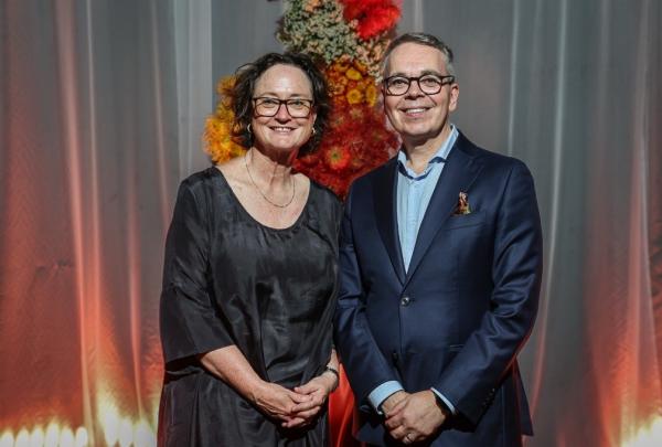 Business Events Sydney CEO Amanda Lampe and Tourism Australia Acting Managing Director Robin Mack posing together at an event, with a vibrant red curtain behind them. © Tourism Australia