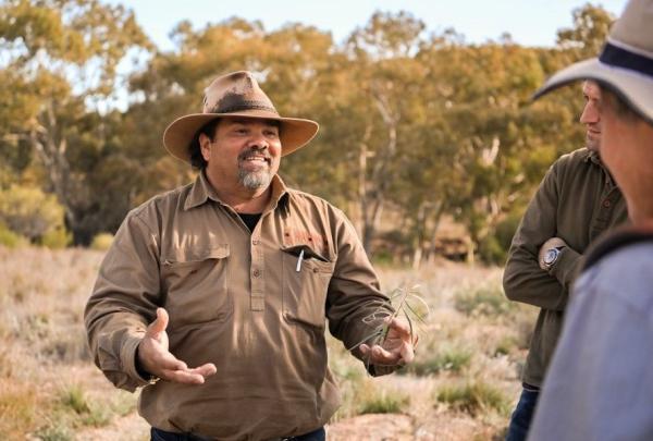A Wadna tour guide presents to attendees against a bush backdrop.
