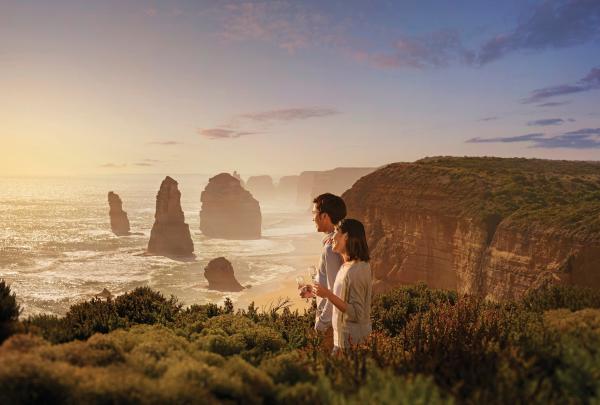 Couple looking out to a view of the Twelve Apostles on the Great Ocean Road, Victoria © Tourism Australia