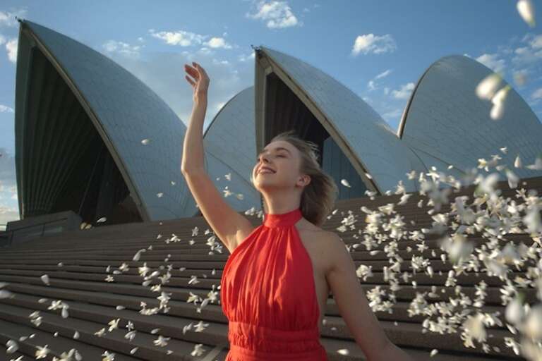 Woman in a red dress dancing on the steps of the Sydney Opera House, Experience Australia in 8D Sound © Tourism Australia