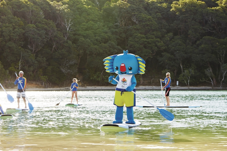 Mascot of the Gold Coast 2018 Commonwealth Games standing next to a yellow lifeguard tower, Gold Coast, Queensland © Tourism Australia