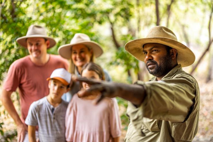 Culture Connect guide pointing as family listen in background, Tropical North Queensland © Tourism Australia