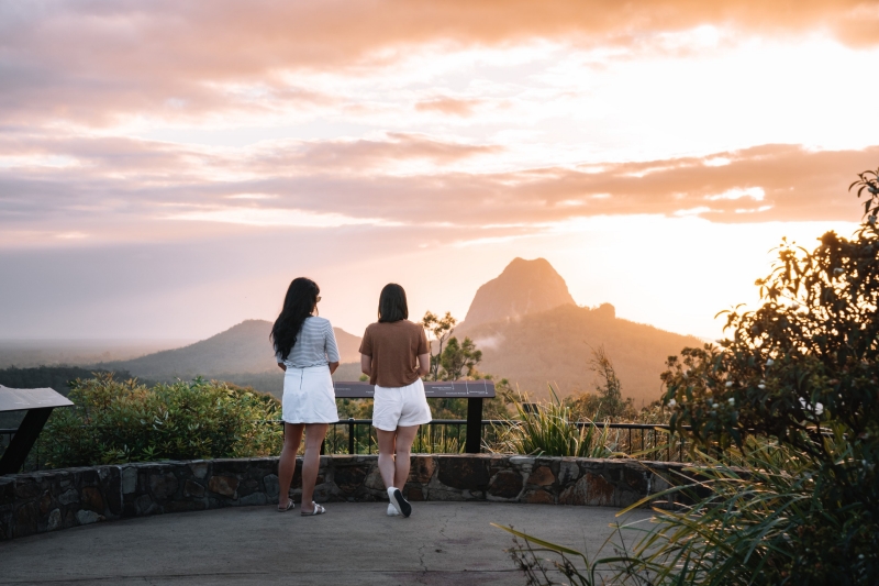 Two friends admiring the sunset view of the Glass House Mountains, Sunshine Coast, Queensland © Tourism and Events Queensland