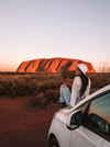 Girl posing on a car at Uluru, Uluru-Kata Tjuta National Park, Northern Territory © Tourism NT/Lola Hubner